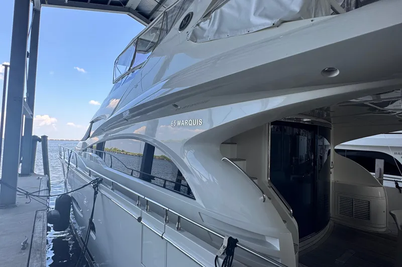 Slide: The Image of Luxury 2006 Marquis 65 yacht docked at marina, showcasing sleek design and elegance. - 13