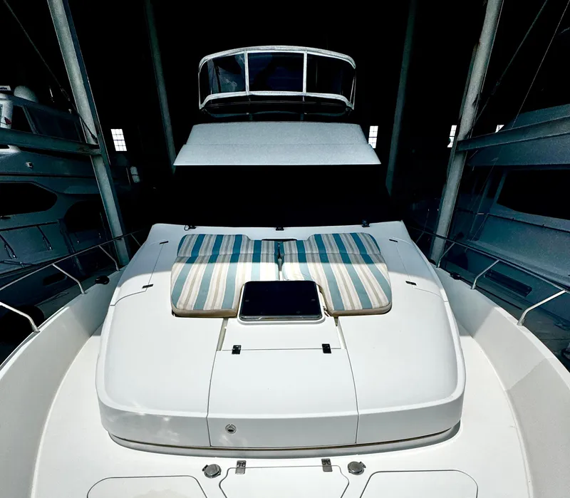 Slide: The Image of 2006 Marquis 65 yacht with striped cushions on deck, docked indoors. - 15