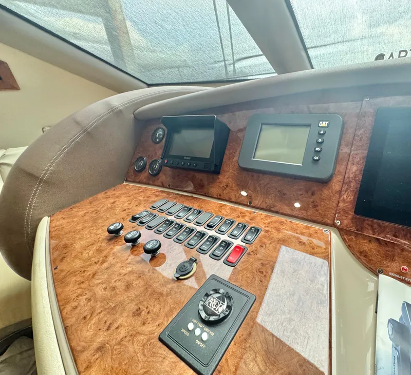 Slide: The Image of Control panel of a 2006 Marquis 65 yacht with wood finish and navigation instruments. - 32