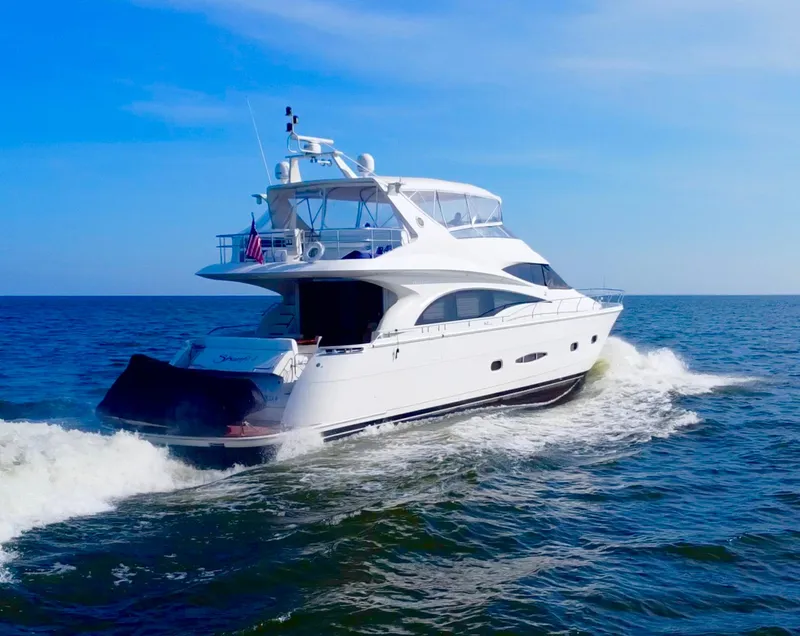 Slide: The Image of Luxurious 2006 Marquis 65 yacht cruising on open sea under clear blue sky. - 4