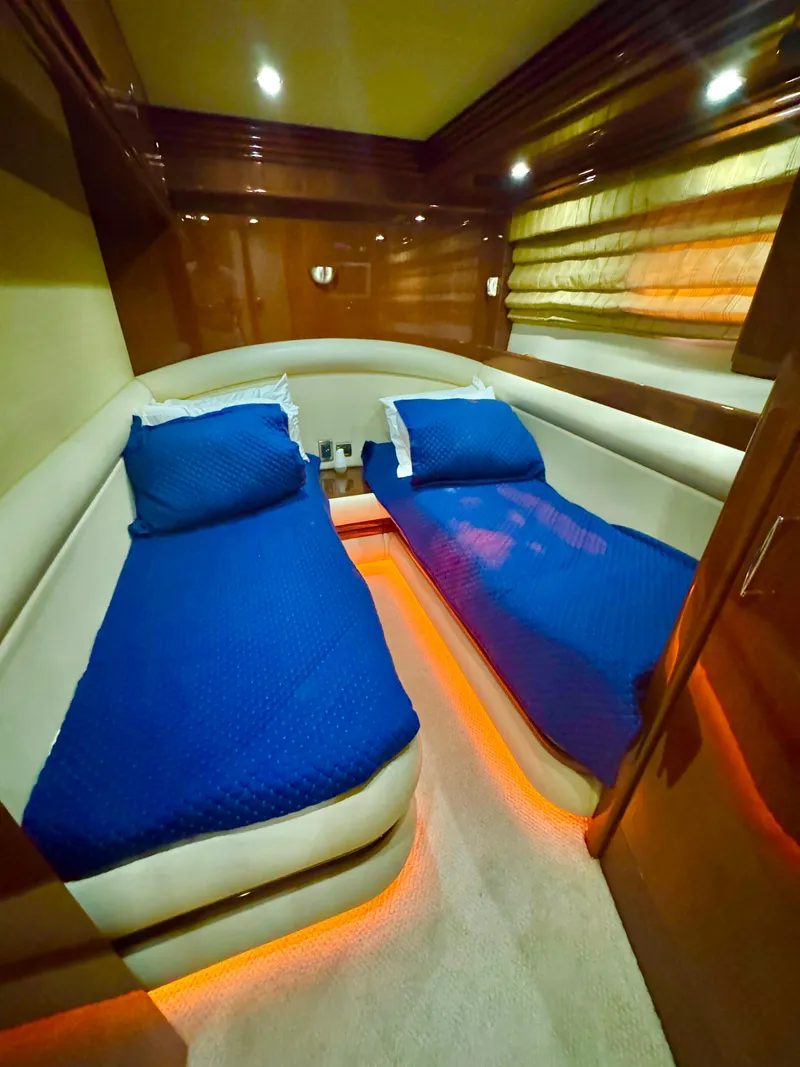 Slide: The Image of Luxurious twin cabin in 2006 Marquis 65 yacht with blue bedding and ambient lighting. - 47