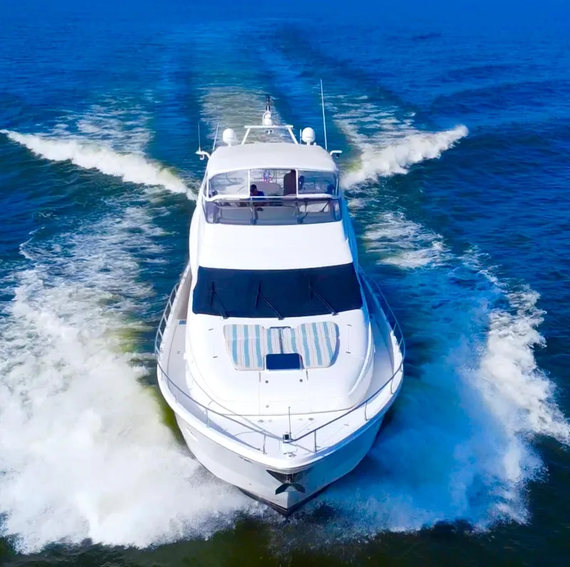 Slide: The Image of Luxury 2006 Marquis 65 yacht cruising on open water, creating a dynamic wake. - 5