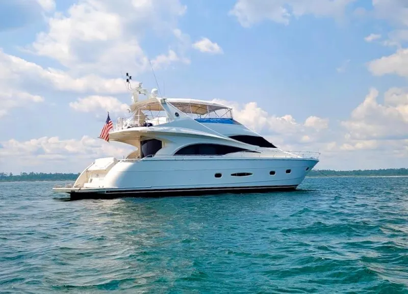 Slide: The Image of 2006 Marquis 65 yacht cruising on open water under a partly cloudy sky. - 8