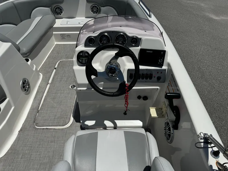 Slide: The Image of 2022 NauticStar 193SC boat interior with steering wheel and seating area. - 12