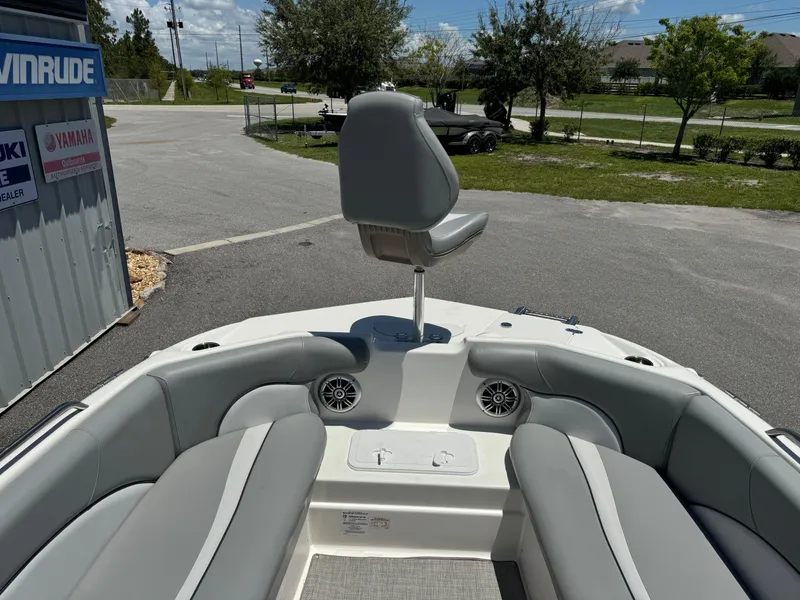 Slide: The Image of 2022 NauticStar 193SC boat interior with seating and helm chair, parked outdoors. - 5