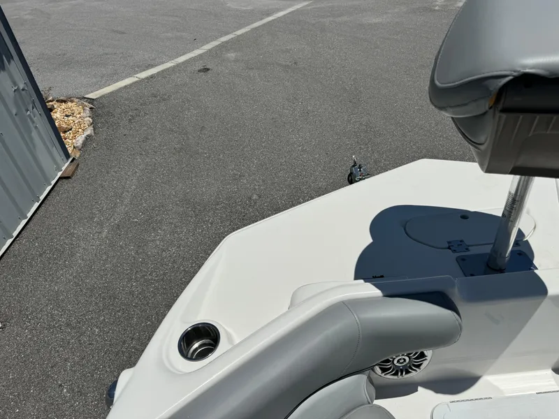 Slide: The Image of 2022 NauticStar 193SC boat interior with seating and cup holder, parked on asphalt. - 6