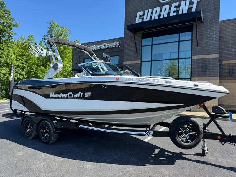 The Image of 2020 MasterCraft XT22 boat on trailer outside dealership, showcasing sleek design and modern features. - 1