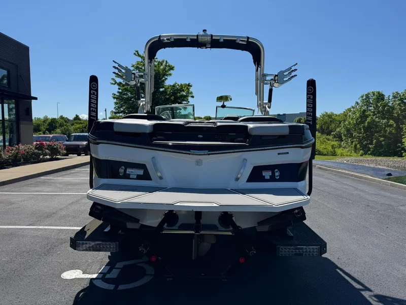 Slide: The Image of 2020 MasterCraft XT22 boat, rear view, parked outdoors on a sunny day. - 3