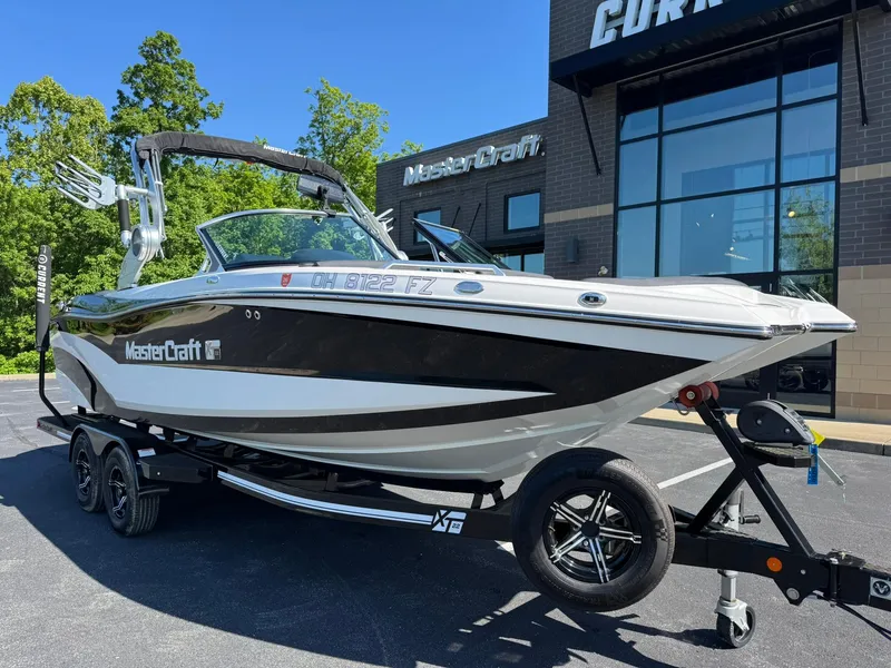 Slide: The Image of 2020 MasterCraft XT22 boat on trailer outside dealership, showcasing sleek design and modern features. - 7