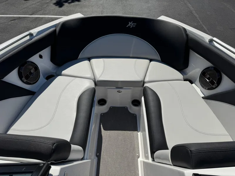 Slide: The Image of 2020 MasterCraft XT22 boat interior with black and white seating and built-in speakers. - 8
