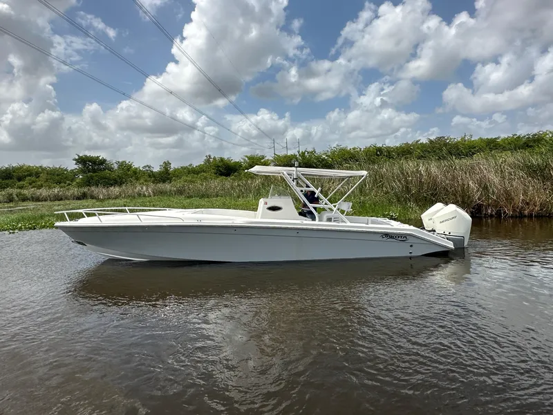 Slide: The Image of 2006 Dakota 36 Cuddy boat on calm water under a partly cloudy sky. - 0
