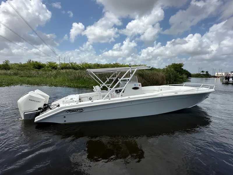 Slide: The Image of 2006 Dakota 36 Cuddy boat on calm water under a partly cloudy sky. - 2