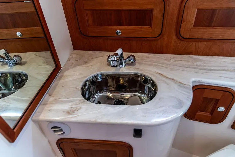 Slide: The Image of Elegant bathroom sink in 2022 Hinckley 35 yacht, featuring marble countertop and wooden cabinetry. - 32