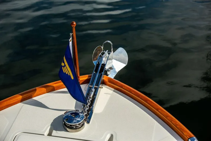 Slide: The Image of Bow of 2022 Hinckley 35 yacht with flag and anchor on calm water. - 34