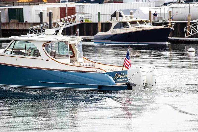 Slide: The Image of Hinckley 35 boat, 2022 model, cruising in a marina with American flag. - 5