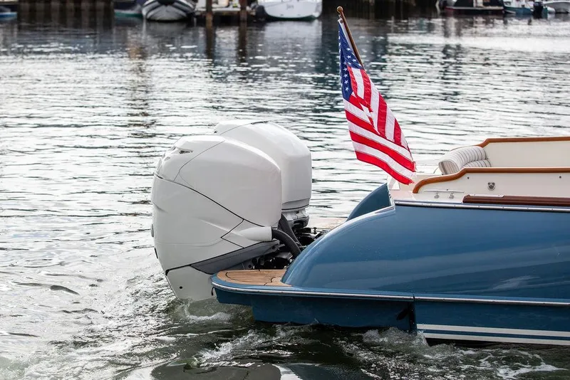Slide: The Image of Hinckley 35 boat, 2022 model, with American flag and outboard motor on water. - 9