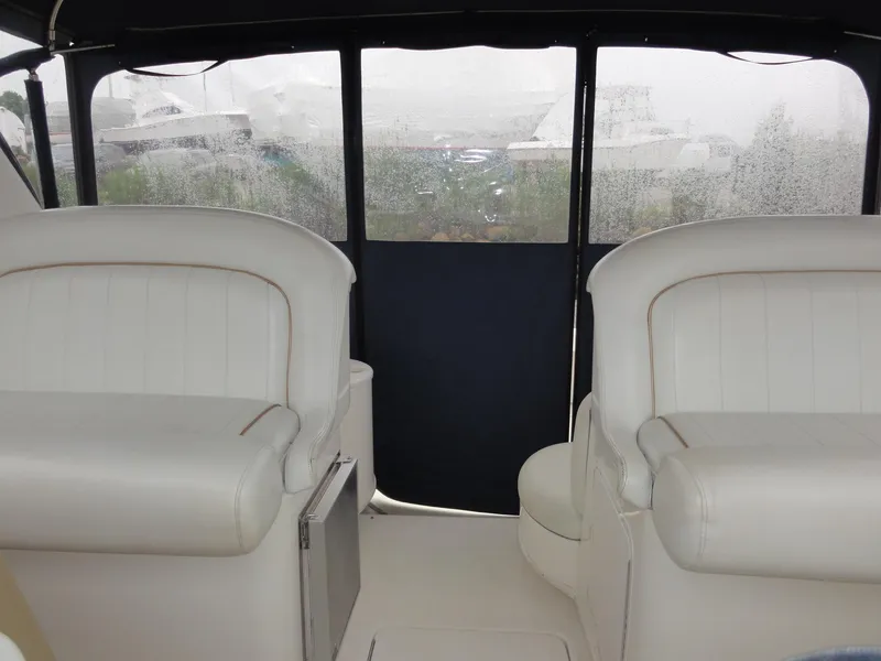 Slide: The Image of Interior of a 1997 Sea Ray 330 Express boat with white seating and window view. - 11
