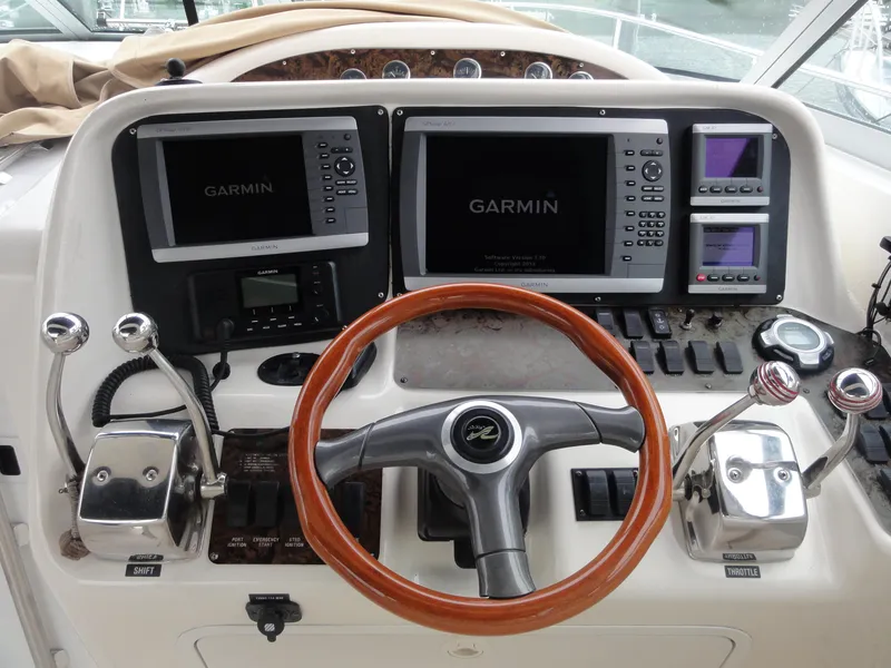 Slide: The Image of 1997 Sea Ray 330 Express helm with Garmin navigation systems and wooden steering wheel. - 17
