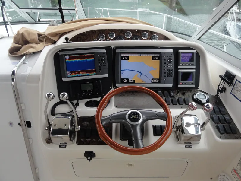 Slide: The Image of 1997 Sea Ray 330 Express helm with navigation screens and wooden steering wheel. - 18