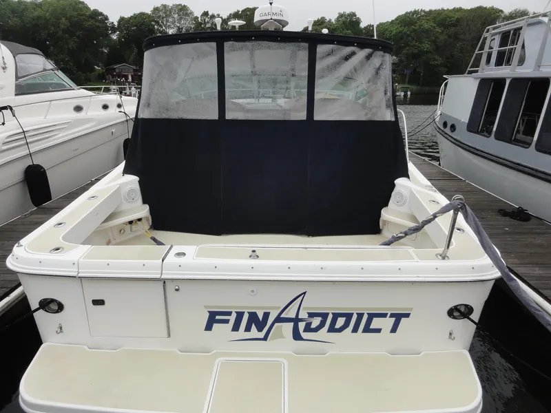 Slide: The Image of 1997 Sea Ray 330 Express boat named "Fin Addict" docked at a marina. - 2