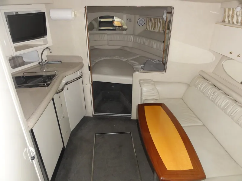 Slide: The Image of 1997 Sea Ray 330 Express cabin interior with kitchenette, seating, and sleeping area. - 22