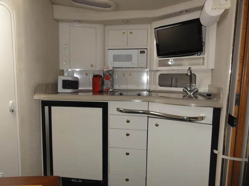 Slide: The Image of 1997 Sea Ray 330 Express yacht kitchen with cabinets, microwave, and sink. - 24
