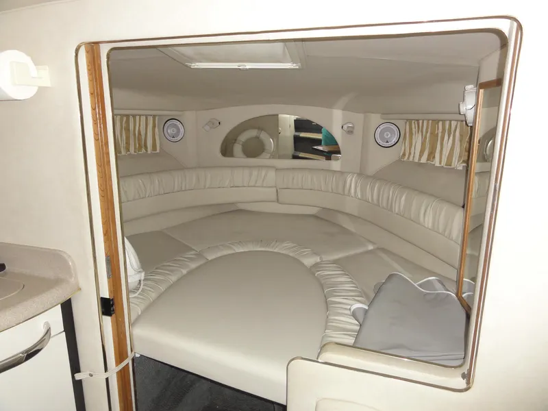 Slide: The Image of 1997 Sea Ray 330 Express cabin interior with circular seating and beige upholstery. - 25