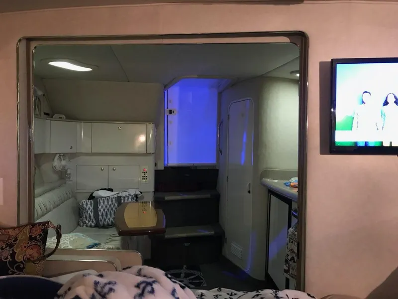 Slide: The Image of Interior of a 1997 Sea Ray 330 Express boat with cozy seating and a TV. - 29