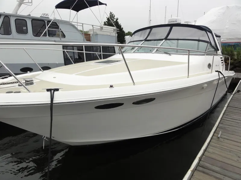 Slide: The Image of 1997 Sea Ray 330 Express docked at marina, showcasing sleek design and spacious deck. - 7