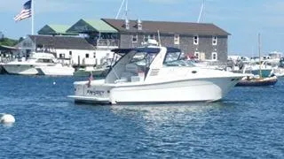 Slide: The Image of 1997 Sea Ray 330 Express boat docked in a marina with buildings in the background. - 8