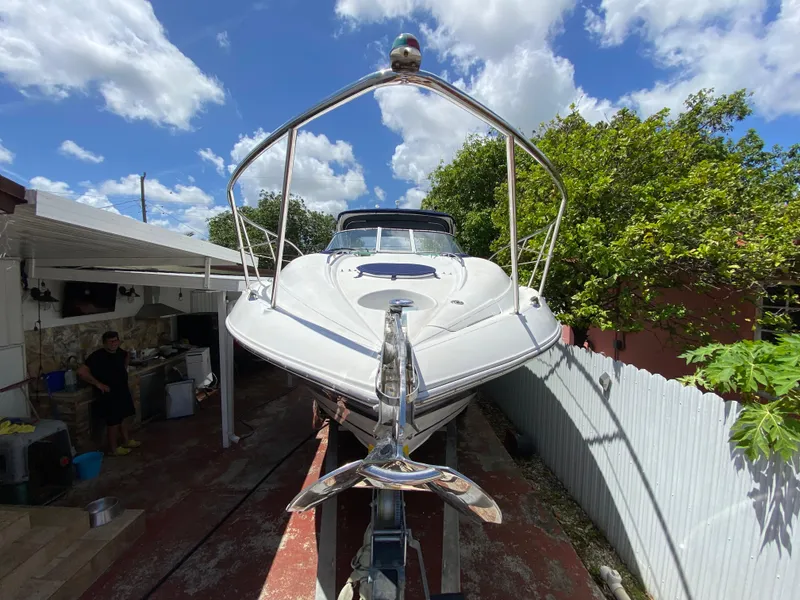 Slide: The Image of 2006 Doral 310 Intrigue boat on trailer, sunny day, blue sky, residential background. - 12
