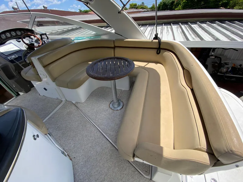 Slide: The Image of 2006 Doral 310 Intrigue boat with beige seating and small round table. - 15