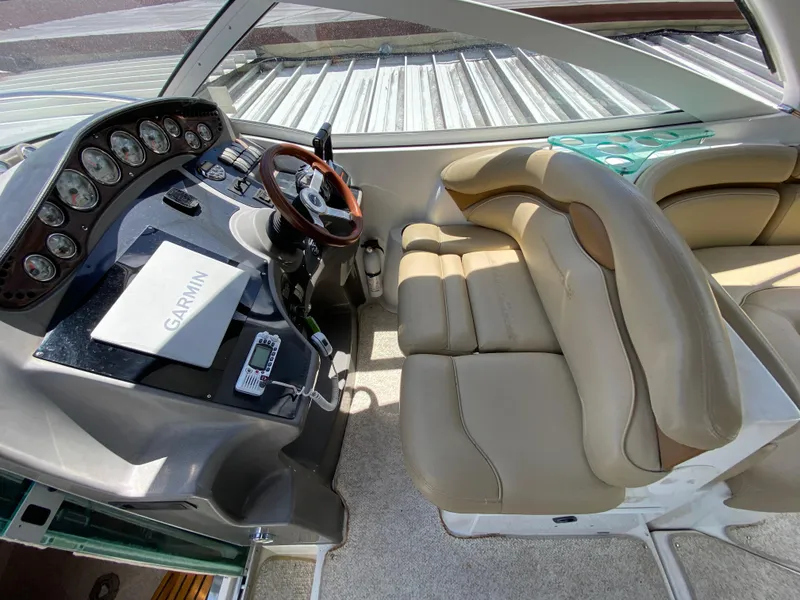 Slide: The Image of 2006 Doral 310 Intrigue boat cockpit with beige leather seats and Garmin navigation system. - 18
