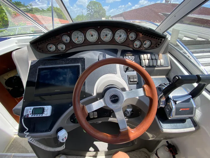 Slide: The Image of 2006 Doral 310 Intrigue boat dashboard with steering wheel and control panel. - 19