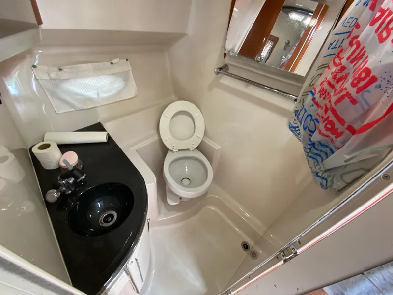 Slide: The Image of 2006 Doral 310 Intrigue boat bathroom with toilet, sink, and shower area. - 26