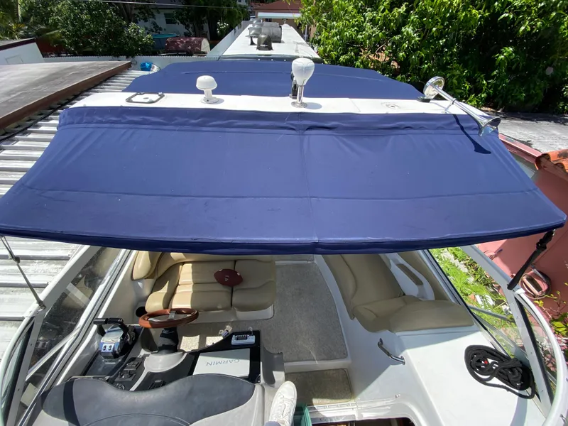 Slide: The Image of 2006 Doral 310 Intrigue boat with blue canopy and beige interior, viewed from above. - 28