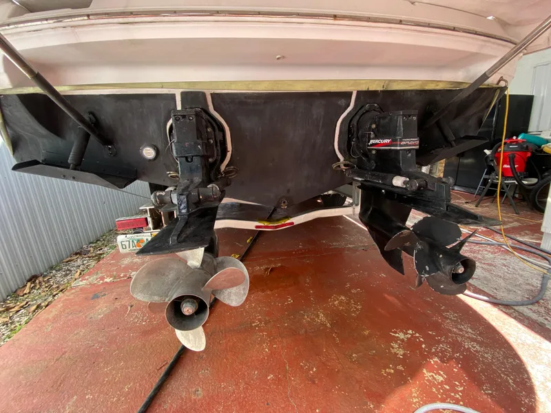 Slide: The Image of 2006 Doral 310 Intrigue boat stern with dual propellers on a red surface. - 29