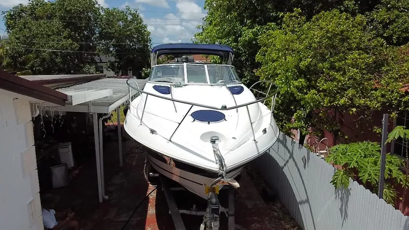 Slide: The Image of 2006 Doral 310 Intrigue boat on trailer, surrounded by trees and a house. - 5