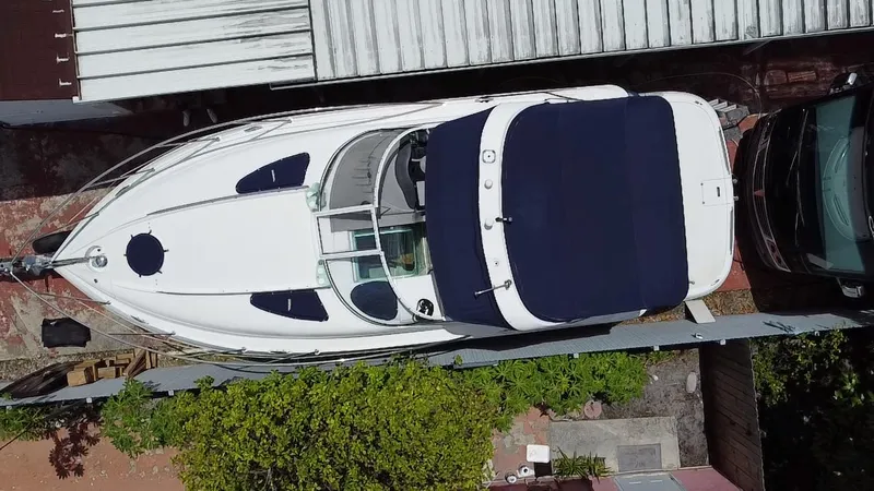 Slide: The Image of 2006 Doral 310 Intrigue boat, aerial view, docked with blue canopy. - 9