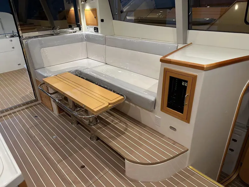 Slide: The Image of 2025 ArrowCat 420 Flybridge interior with sleek seating, wooden table, and modern design. - 7