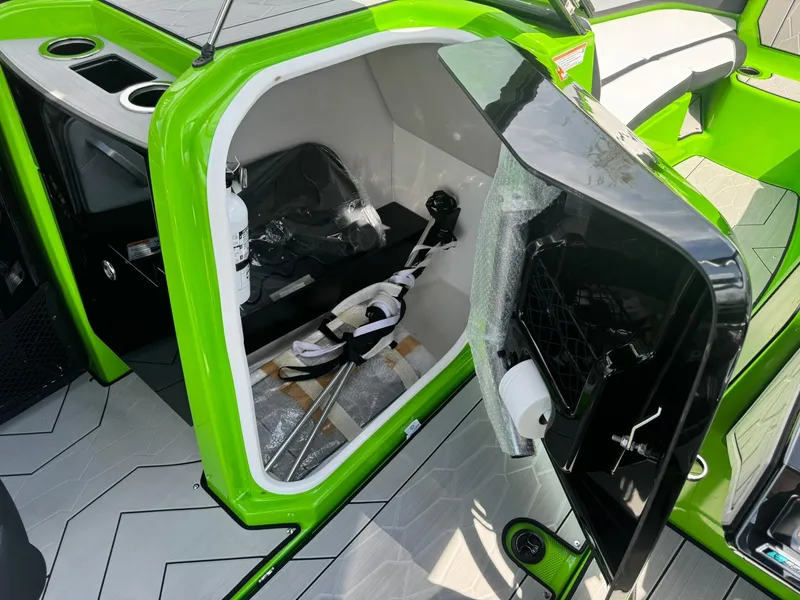 Slide: The Image of 2022 Yamaha Boats 255XD storage compartment with green accents and interior equipment. - 17
