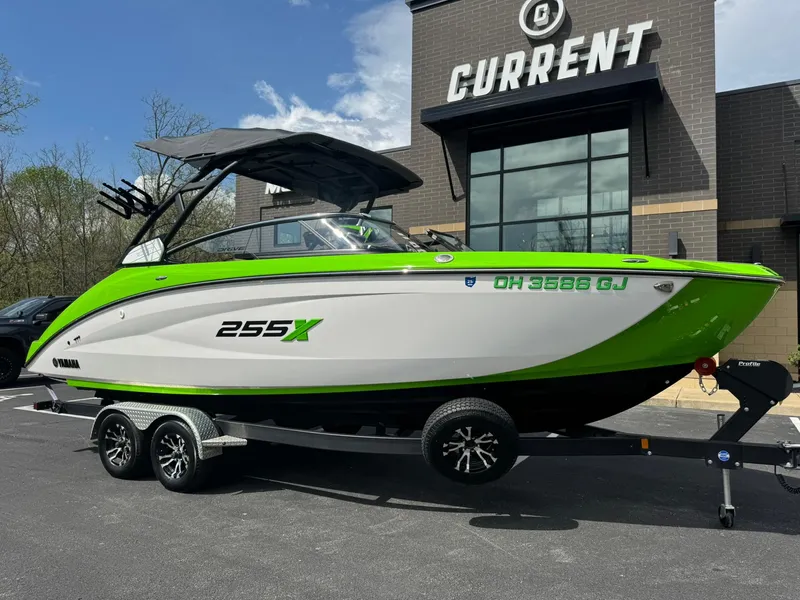 Slide: The Image of 2022 Yamaha Boats 255XD in green and white on a trailer outside a building. - 23