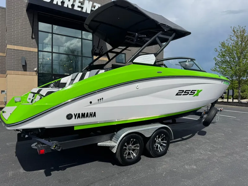 Slide: The Image of 2022 Yamaha Boats 255XD in vibrant green on a trailer, parked outdoors. - 3