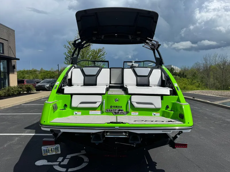 Slide: The Image of 2022 Yamaha Boats 255XD in vibrant green, parked outdoors with open canopy. - 4