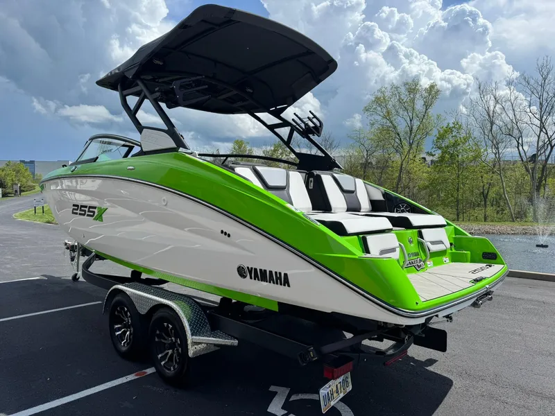 Slide: The Image of 2022 Yamaha Boats 255XD in vibrant green and white, parked on a trailer. - 5