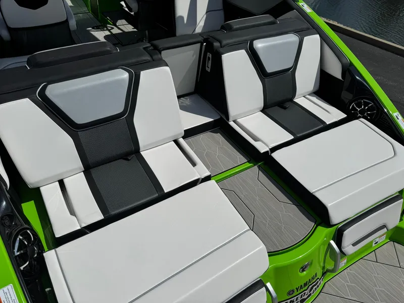 Slide: The Image of 2022 Yamaha Boats 255XD interior with sleek white and black seating, green accents. - 7