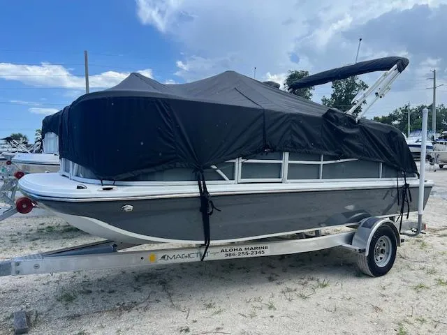 Slide: The Image of 2025 Hurricane FunDeck 1960 RE OB boat on trailer, covered, parked outdoors. - 0