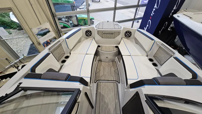 Slide: The Image of 2023 Yamaha Boats 222XD interior, featuring spacious seating and modern design in a showroom setting. - 16