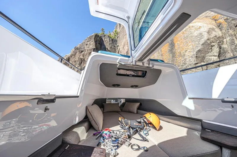 Slide: The Image of 2025 Axopar 37XC CROSS CABIN interior with climbing gear and helmet, open hatch, rocky backdrop. - 3