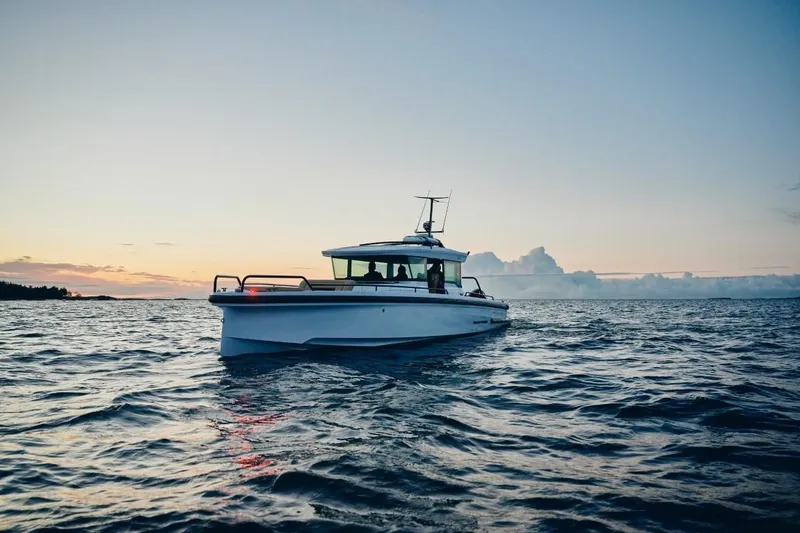 Slide: The Image of 2025 Axopar 37XC CROSS CABIN boat cruising at sunset on open water. - 4